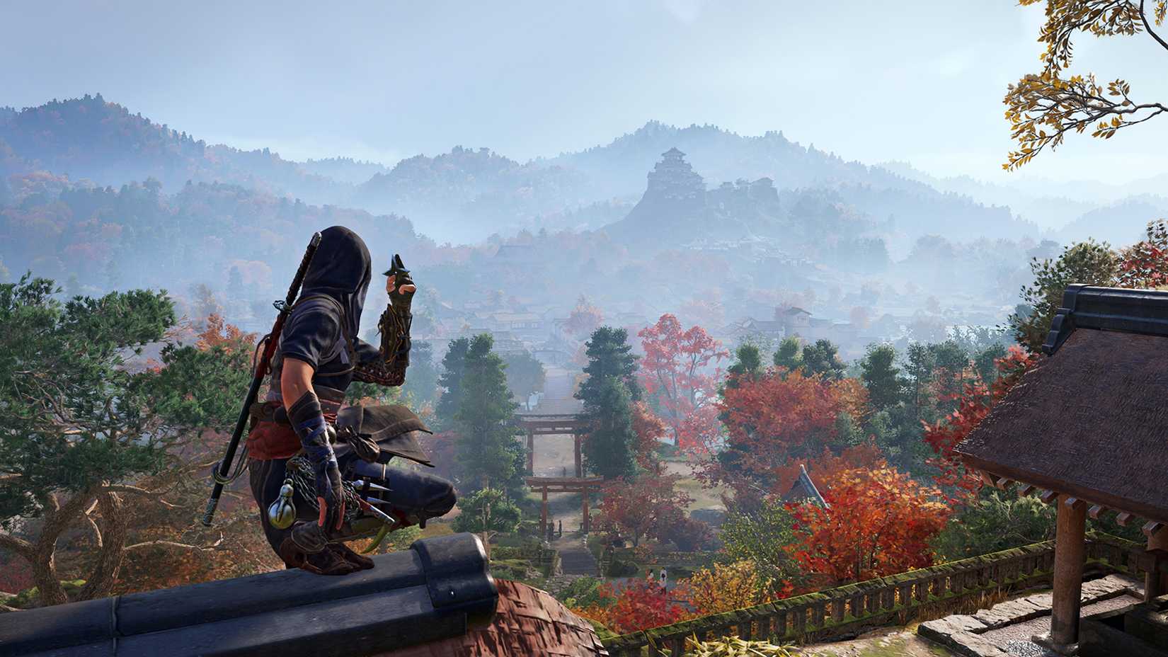A Switch 2 screenshot of Assassin's Creed Shadows shows ninja Naoe crouching on a rooftop overlooking a beautiful fall landscape