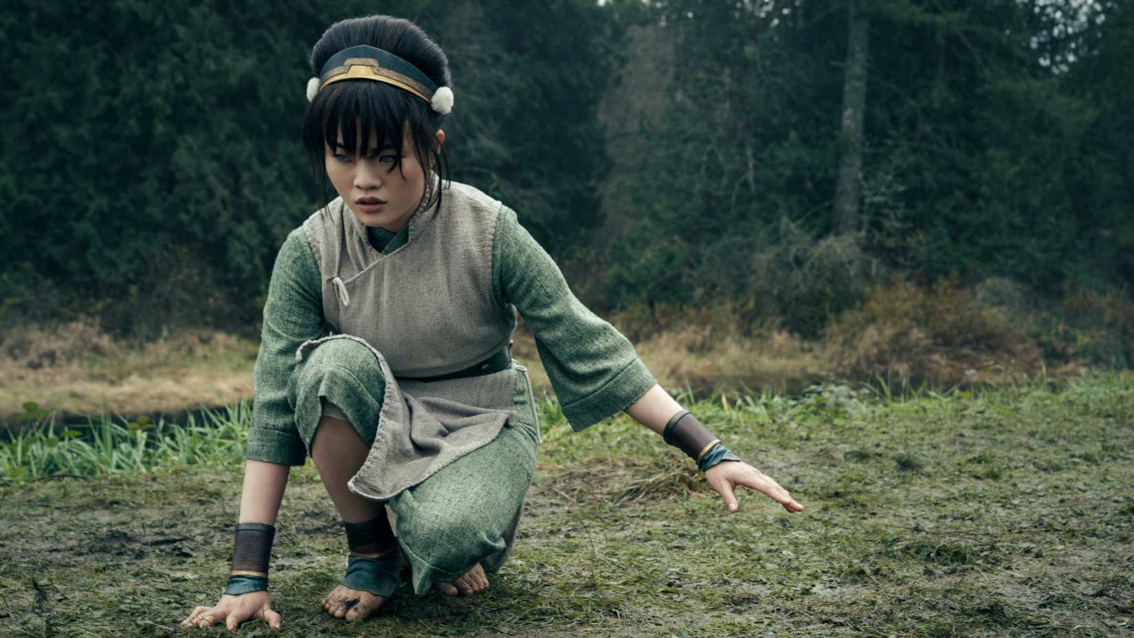 Toph Beifong (Miya Cech) touches the grass to sense something in Avatar: The Last Airbender
