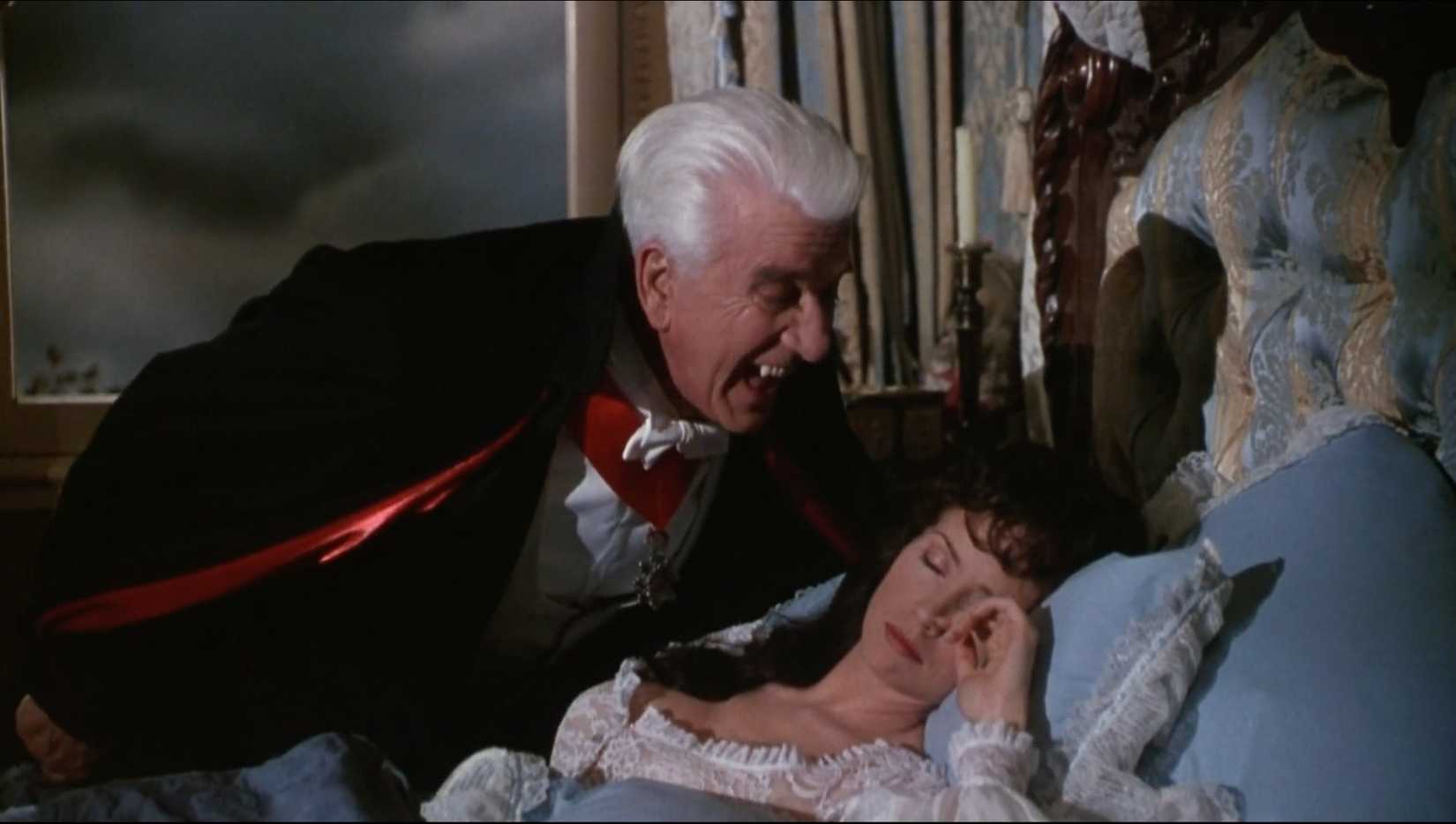 Dracula hovering over a sleeping woman with his fangs out