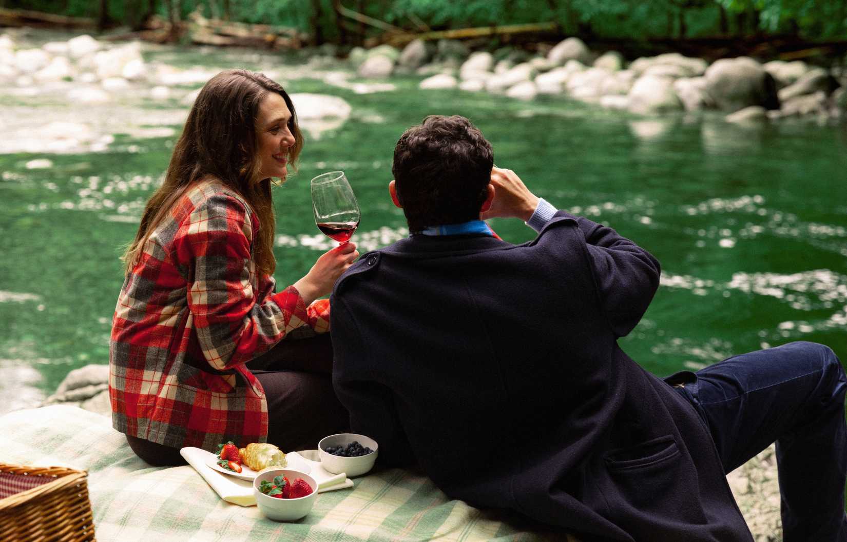 Joan and Luke on a blanket by a mountain stream