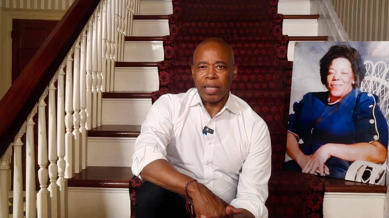 Eric Adams sits on a staircase.