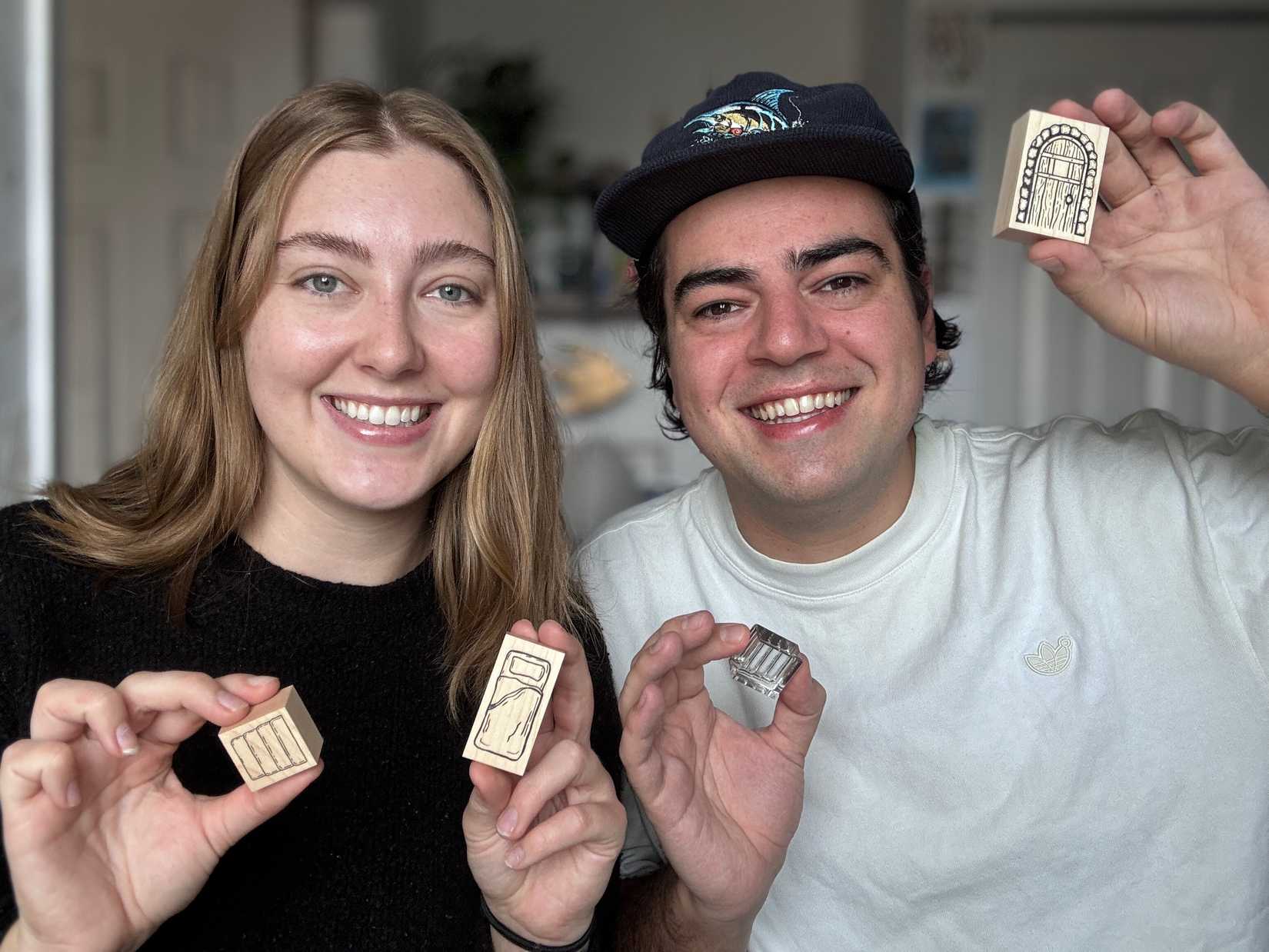 Karoline Moore e Jacob Harris segurando selos de mesa