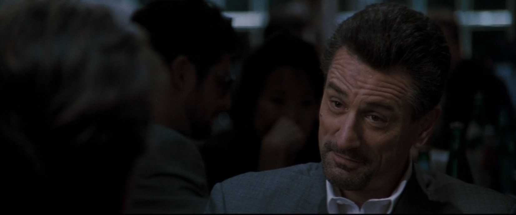 In a scene from the film Heat, the camera zooms in on Robert De Niro suppressing a smile as he sits across the dinner table from Al Pacino (not pictured). They play a criminal and a policeman sitting over a cup of coffee.