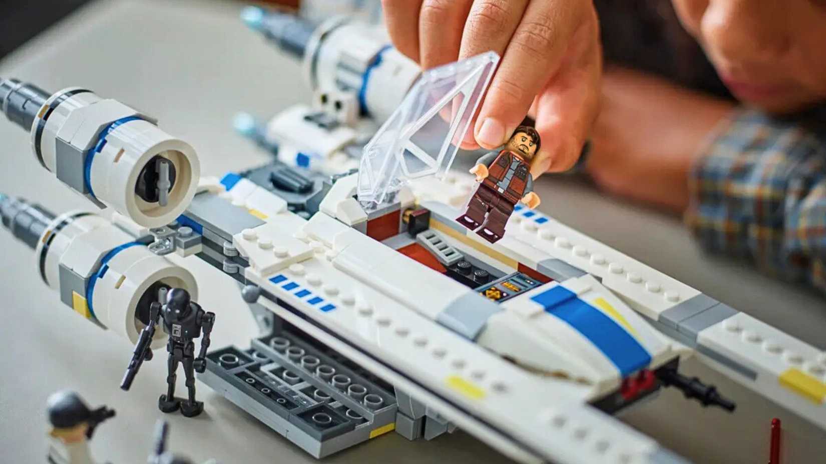 A lifestyle image showing a Lego figure of Cassian Andor.and K2SO on a Rebel U-Wing