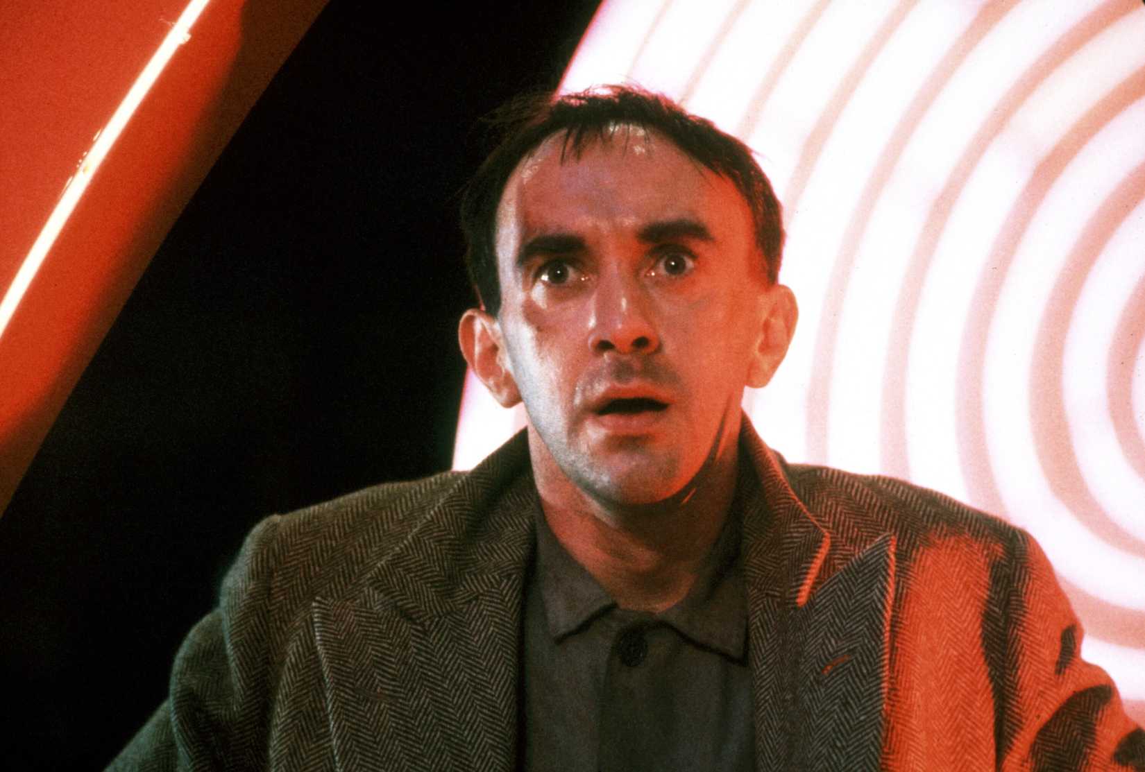 Jonathan Pryce as Sam Lowry, looking terrified amidst dramatic lighting