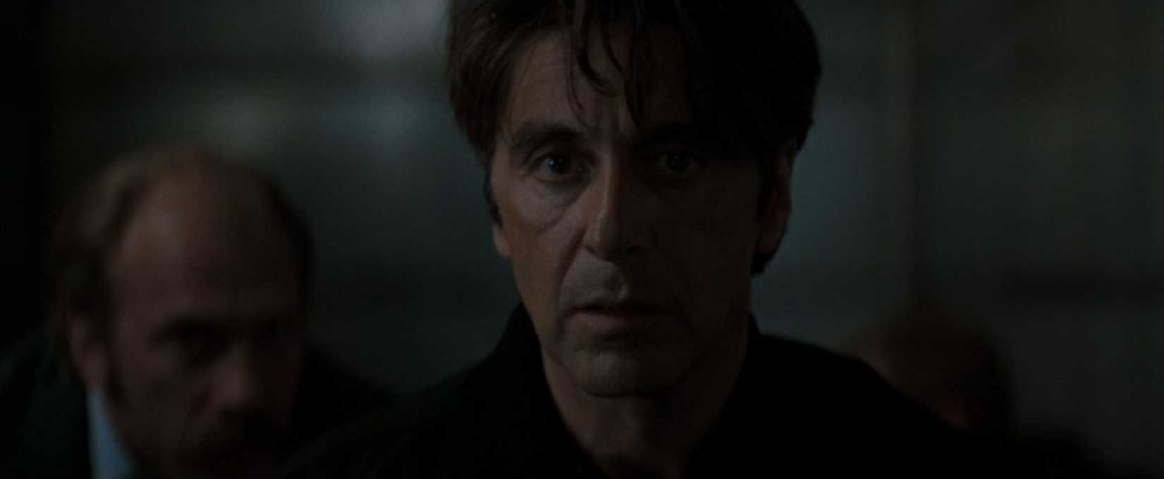In a scene from the movie Heat, Al Pacino's face is seen in partially shadowed close-up as he watches to see whether criminals he's staking out will go through with their heist.