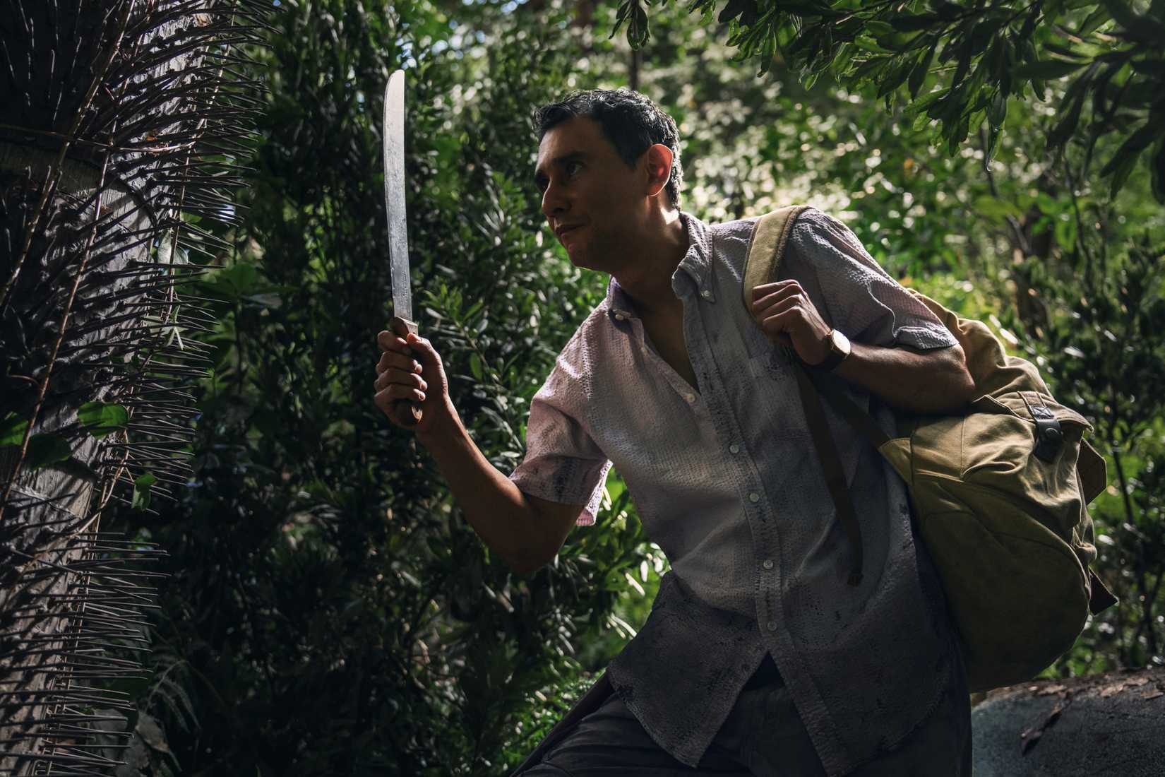 Manousos (Carlos-Manuel Vesga), holding up a machete, makes his sweaty way through the jungle in Pluribus