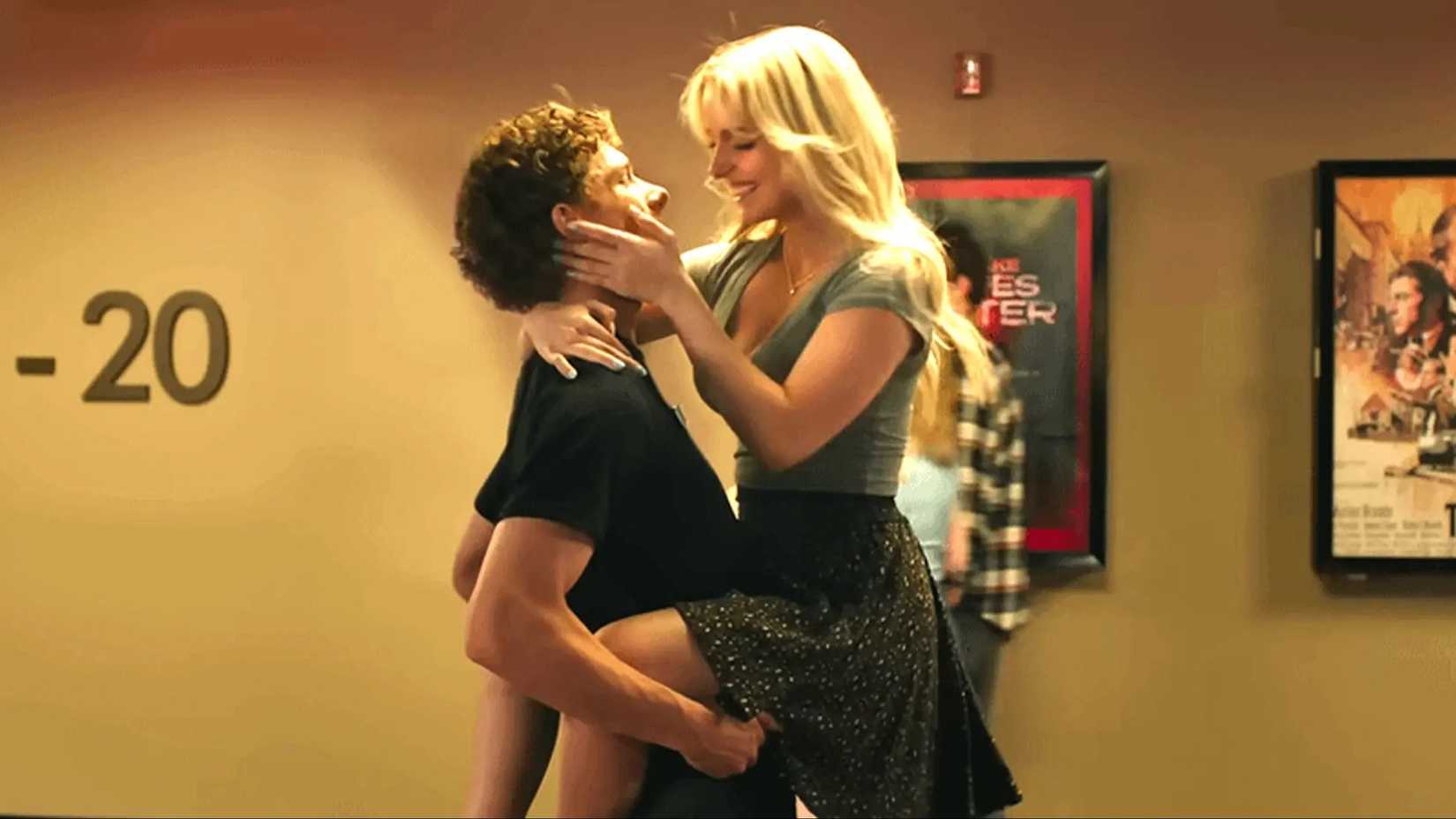 Two teenagers embrace in an AMC movie theater hallway during a scene from the bizarre romance Regretting You