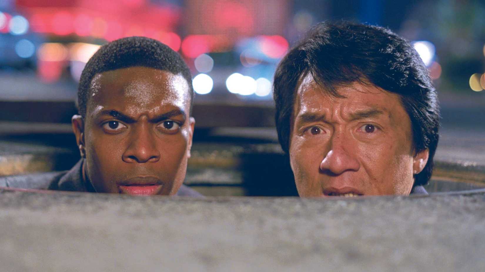 Jackie Chan and Chris Tucker peeking out of a manhole cover in Rush Hour 2
