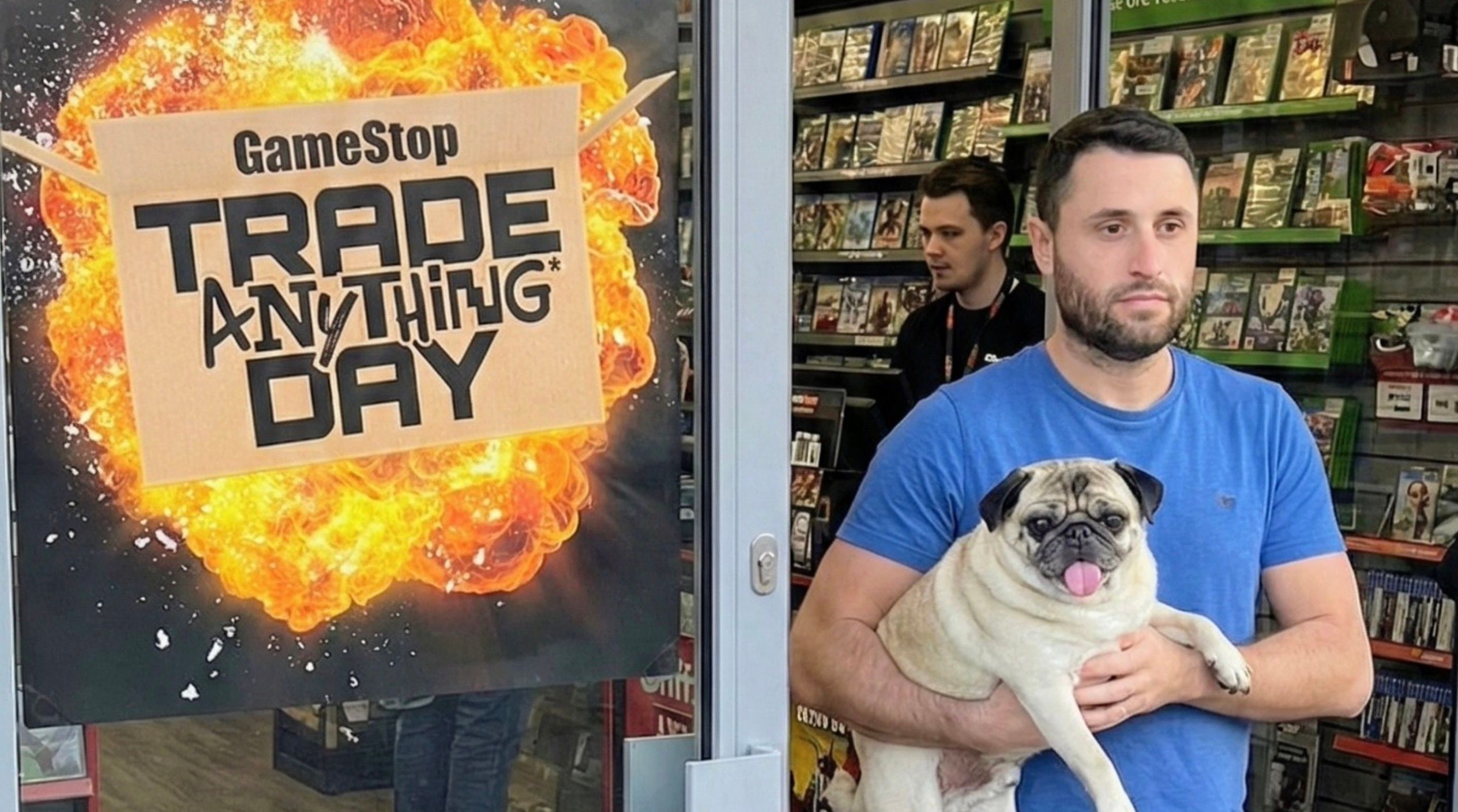 a man carries a pug alongside an advertisement for GameSpot trade anything day