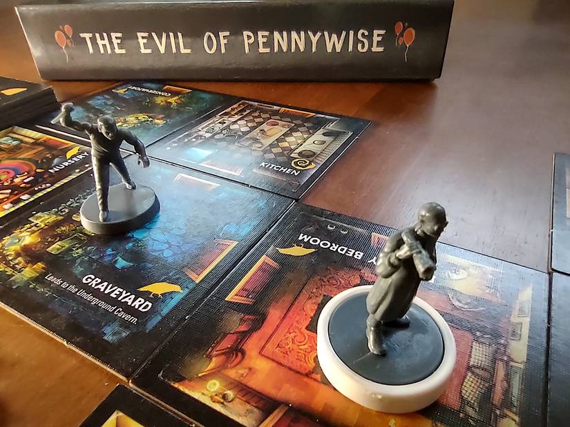 《內博爾特之家的背叛：彭尼懷斯的邪惡》的遊戲設計，其中一個迷你亨利拿著一把刀，在一系列房間瓷磚上追逐一台電腦。