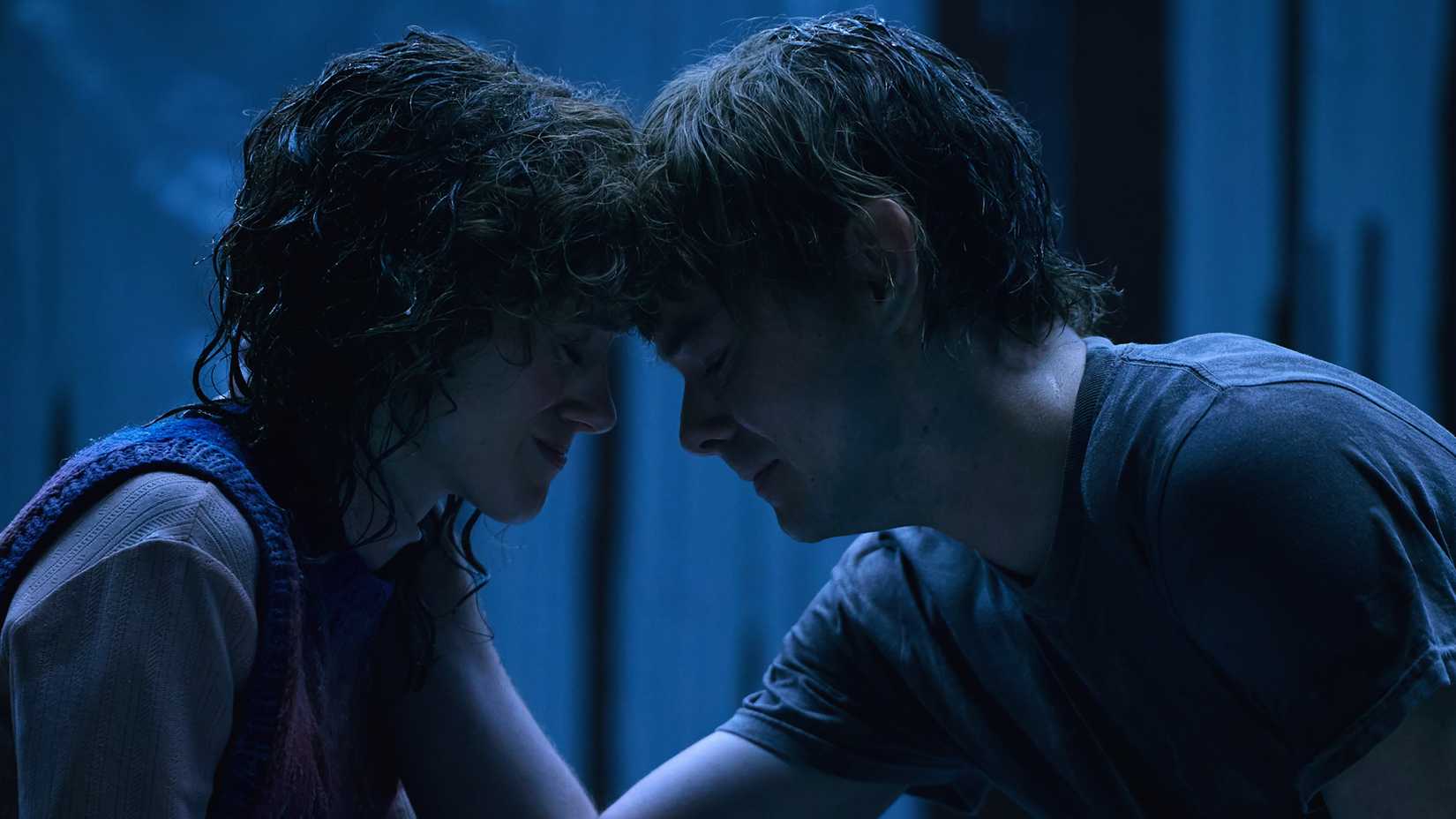 Nancy Wheeler (Natalia Dyer) sits crying with her head pressed against Jonathan Byers (Charlie Heaton) in Stranger Things season 5 