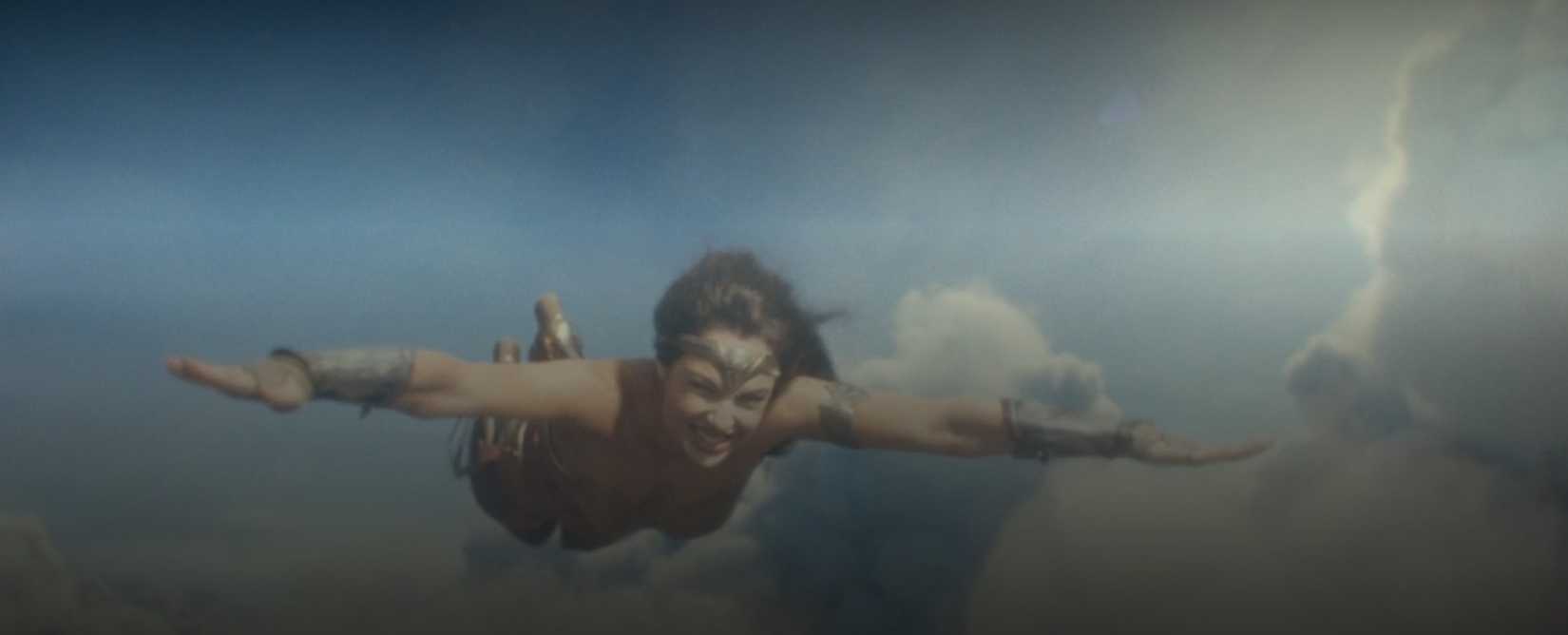 In a scene from Wonder Woman 1984, Diana (Gal Gadot) soars through the air, taking her late boyfriend's advice for how to pilot herself like a jet