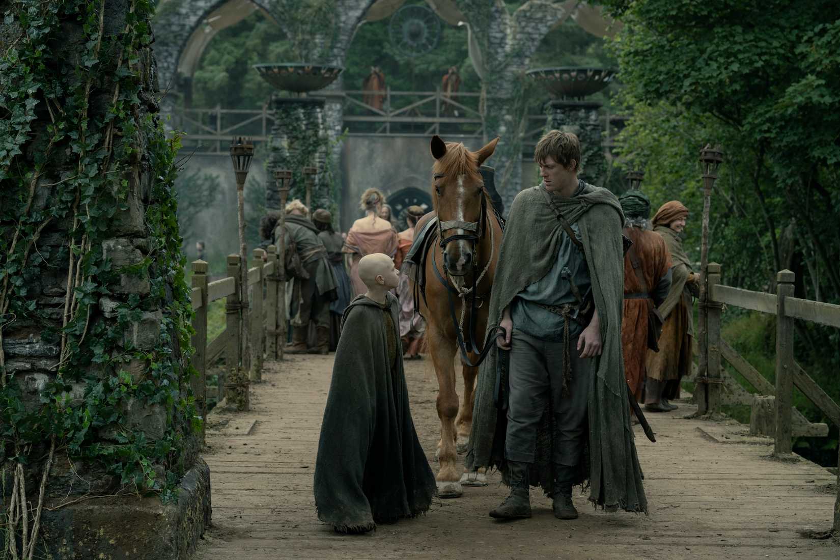 Dunk, a tall, broad-shouldered man, stands on a bridge with Egg, a small bald boy, in the Game of Thrones prequel A Knight of the Seven Kingdoms