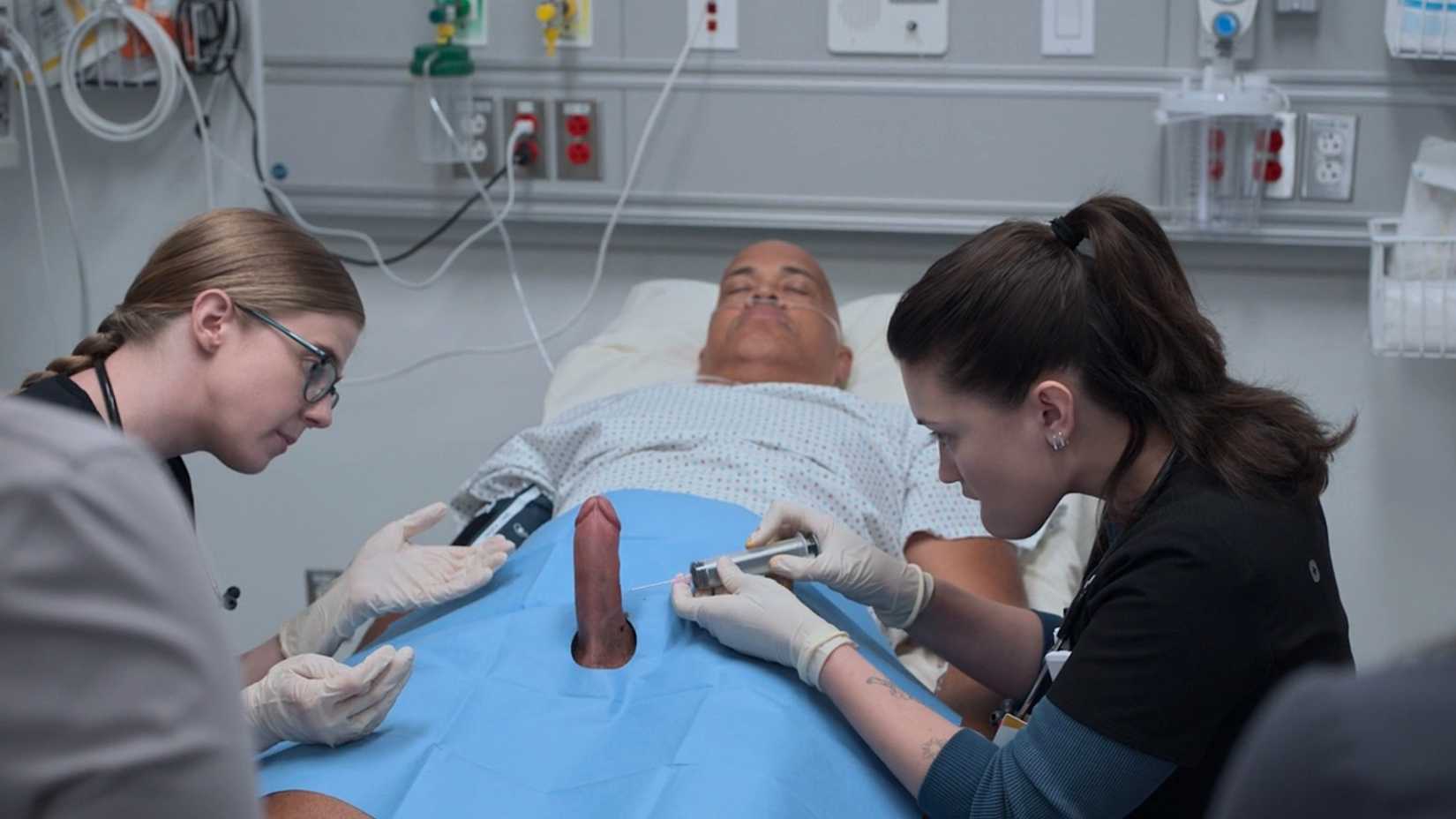 Dr. Mel King (Taylor Dearden) and Dr. Trinity Santos (Isa Briones) use a syringe to drain blood from the errect penis of a patient (Christopher T. Wood)