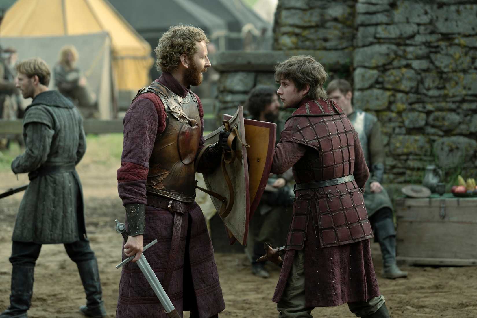 Two men in padded leather armor face off, shield to shield, in the Game of Thrones prequel A Knight of the Seven Kingdoms