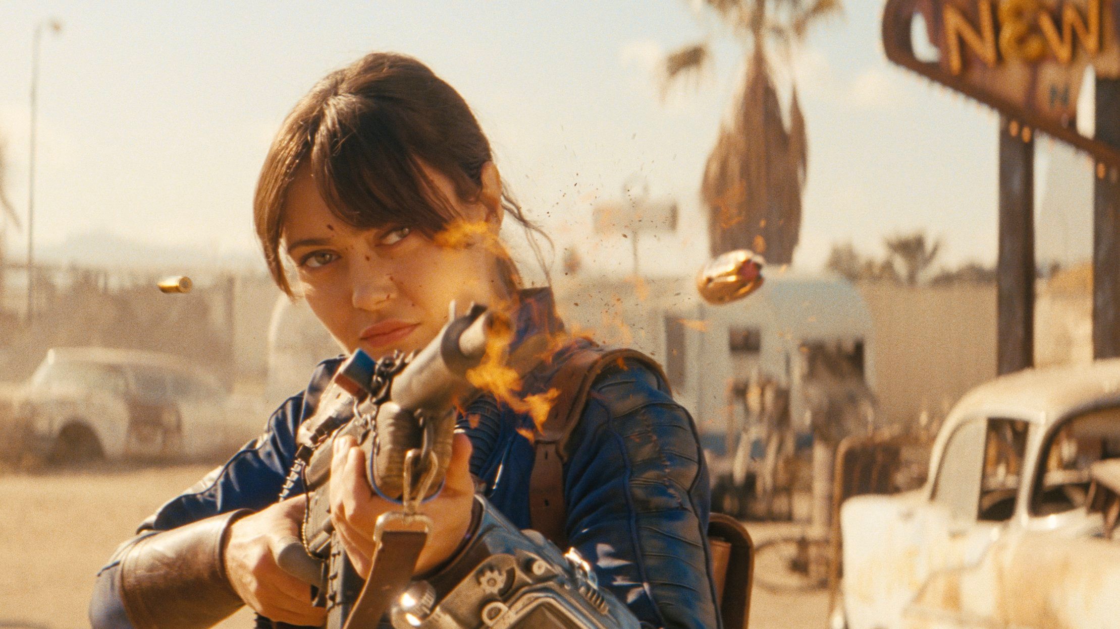 Lucy firing a weapon in front of the New Vegas sign