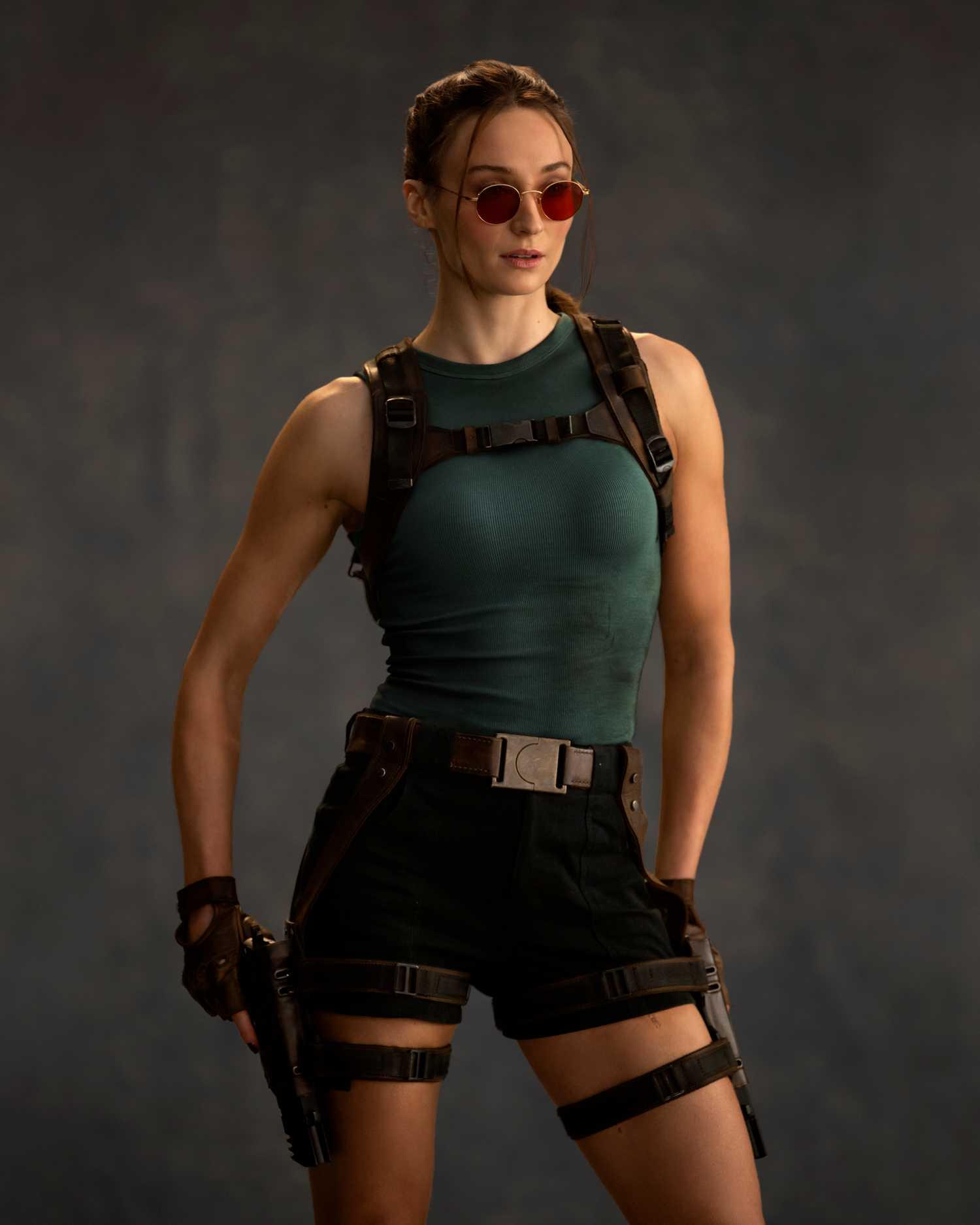 A full-length promotional portrait of Sophie Turner in her Tomb Raider attire