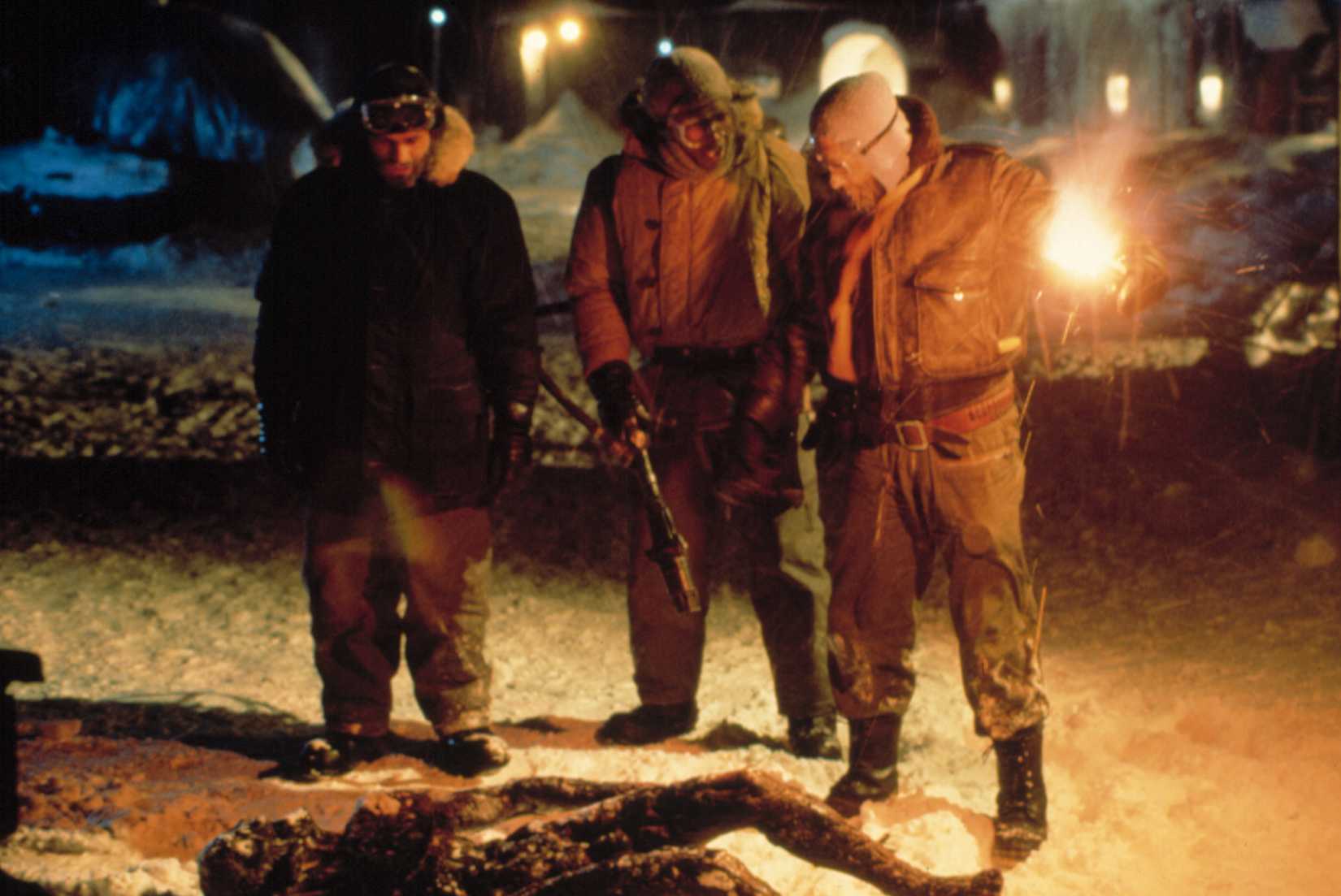MacReady and two researchers look at a burnt corpse in 1982's The Thing