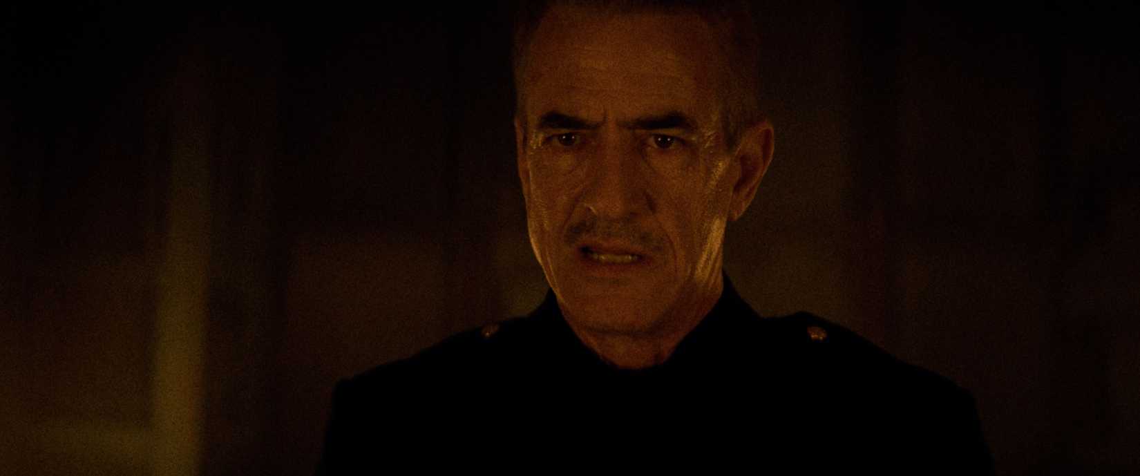 A grim-looking, sweaty, bloodied man (Dermot Mulroney) stares into the camera in Night Patrol