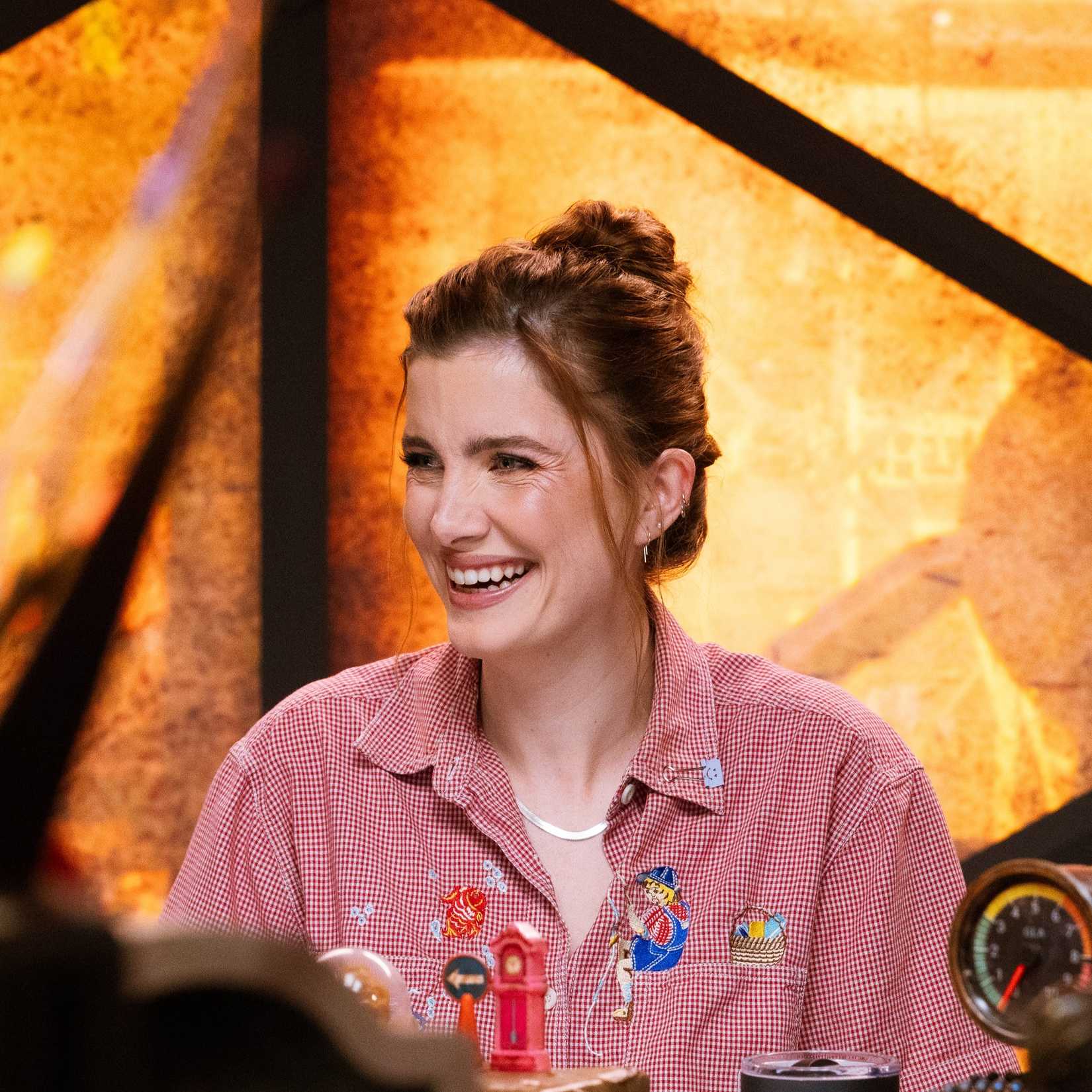 Vic Michaelis smiling at the table for Dimension 20's actual play series Gladlands