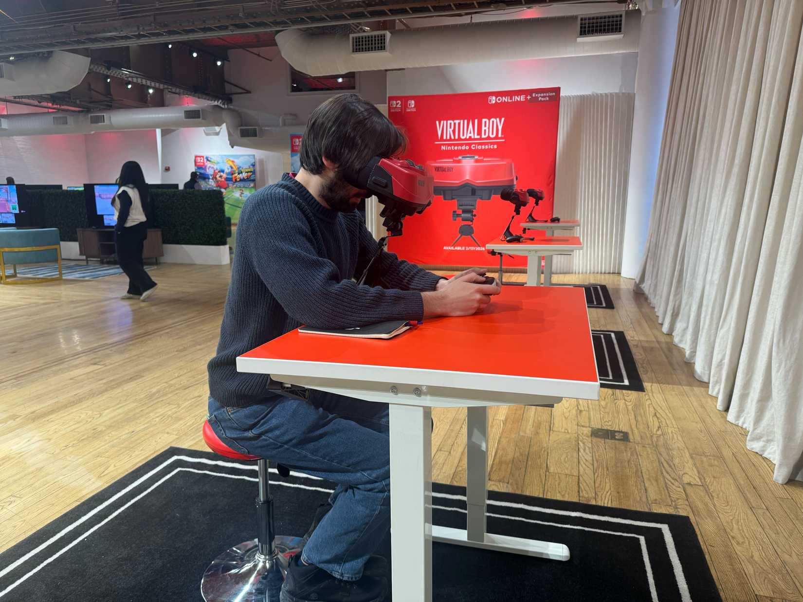 A man uses a Nintendo Switch 2 Virtual Boy at a table.