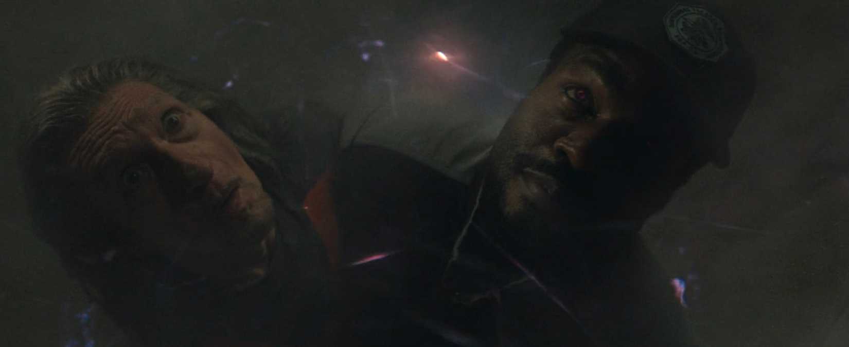 Simon Williams (Yahya Abdul-Mateen II) and Trevor Slattery (Ben Kingsley), standing chest-to-chest with sparkles of energy around them in Wonder Man. Simon's eyes are glowing red.