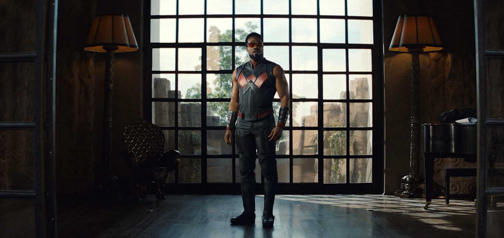 Yahya Abdul-Mateen II on a movie set in costume as the hero Wonder Man, in red sunglasses and a black-and-red leather super-suit