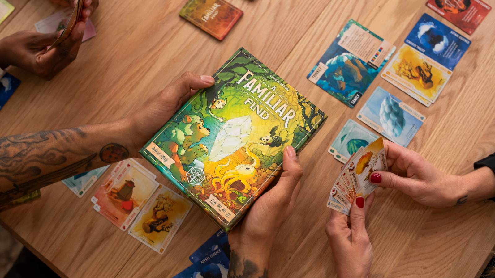 Image of hands holding a board game called A Familiar Find