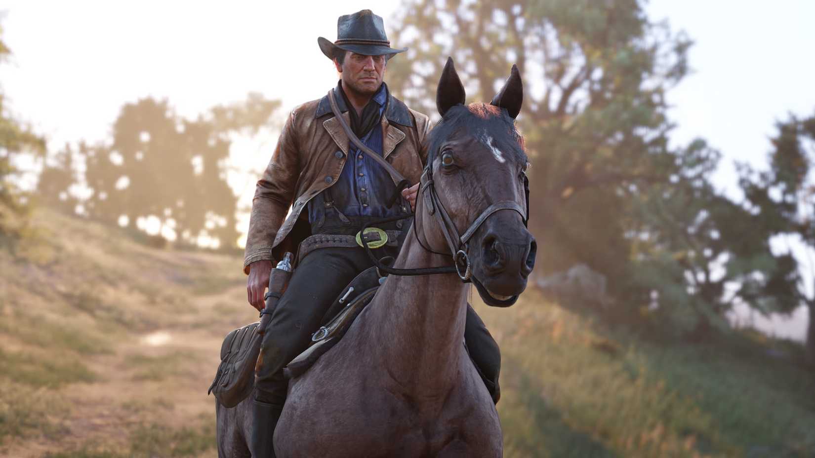 Arthur Morgan rides a horse across a scenic landscape in Red Dead Redemption 2