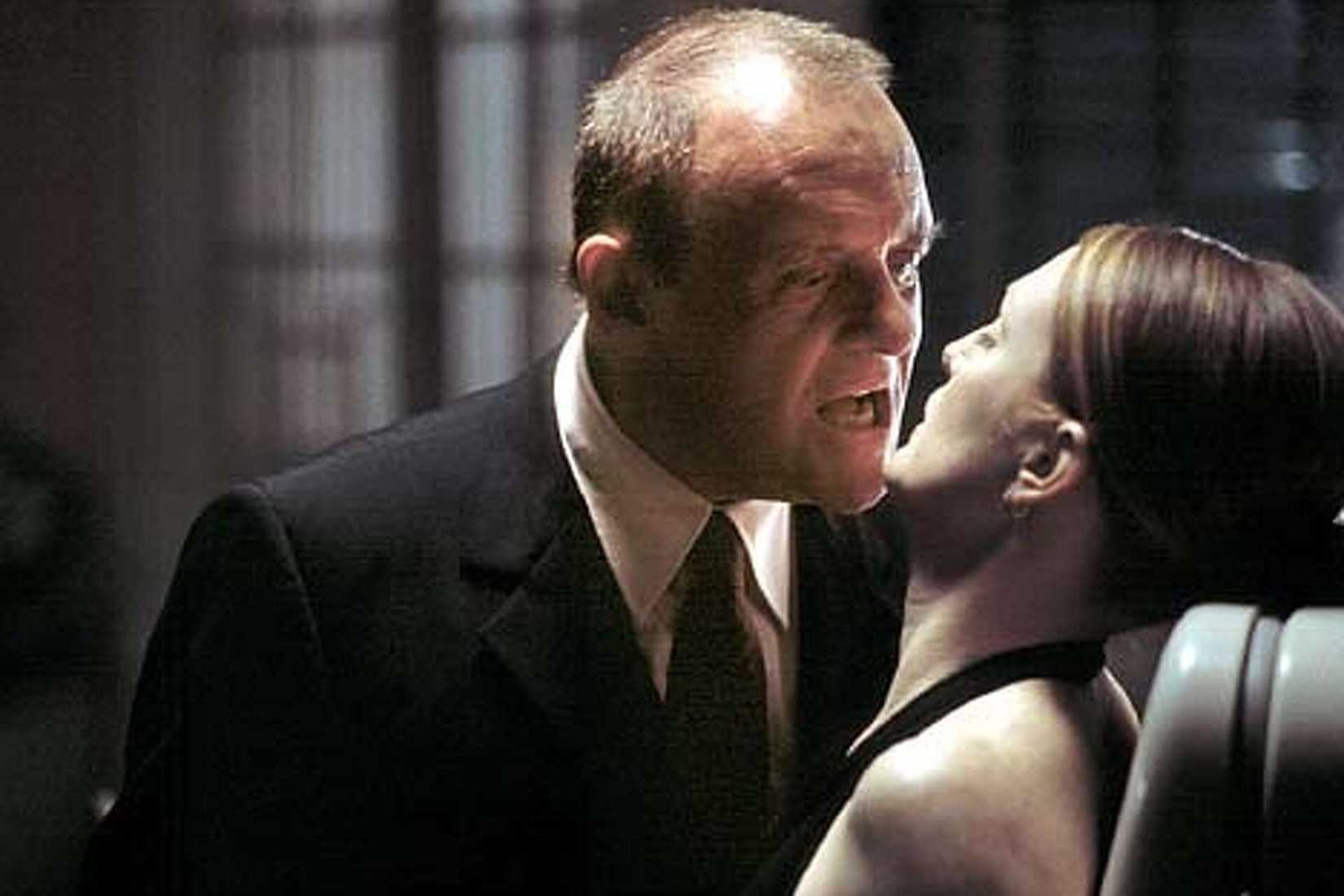 Hannibal Lecter (Anthony Hopkins) leans in menacingly to speak with a trapped Clarice (Julianne Moore), their mouths uncomfortably close, in a scene from Hannibal (2001)