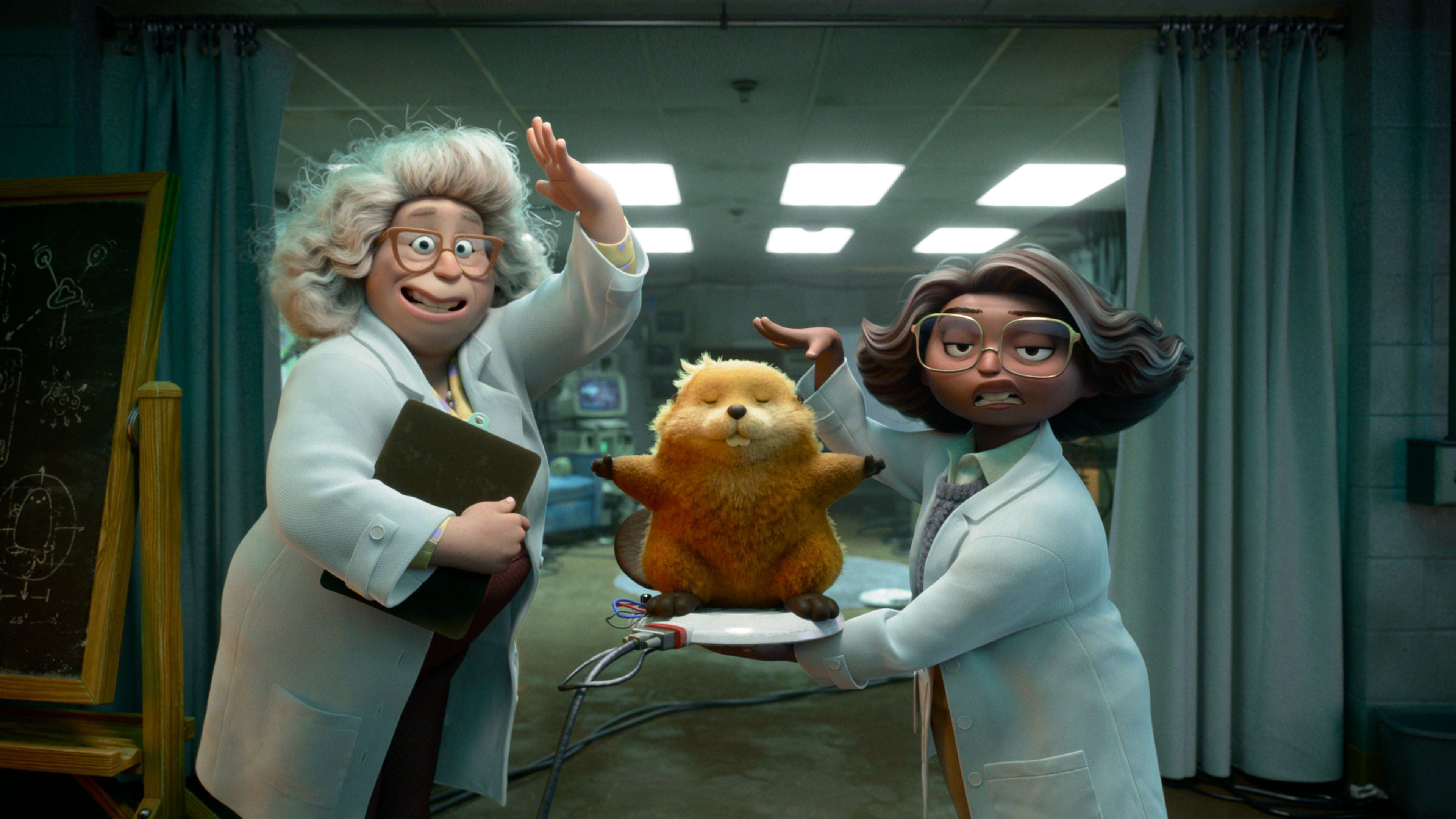 Dr. Sam, a woman with frizzy white hair, and Nisha, a woman with short graying brown hair, both are wearing white labcoats and glasses and showing off a robot beaver on a charging plate in Hoppers 