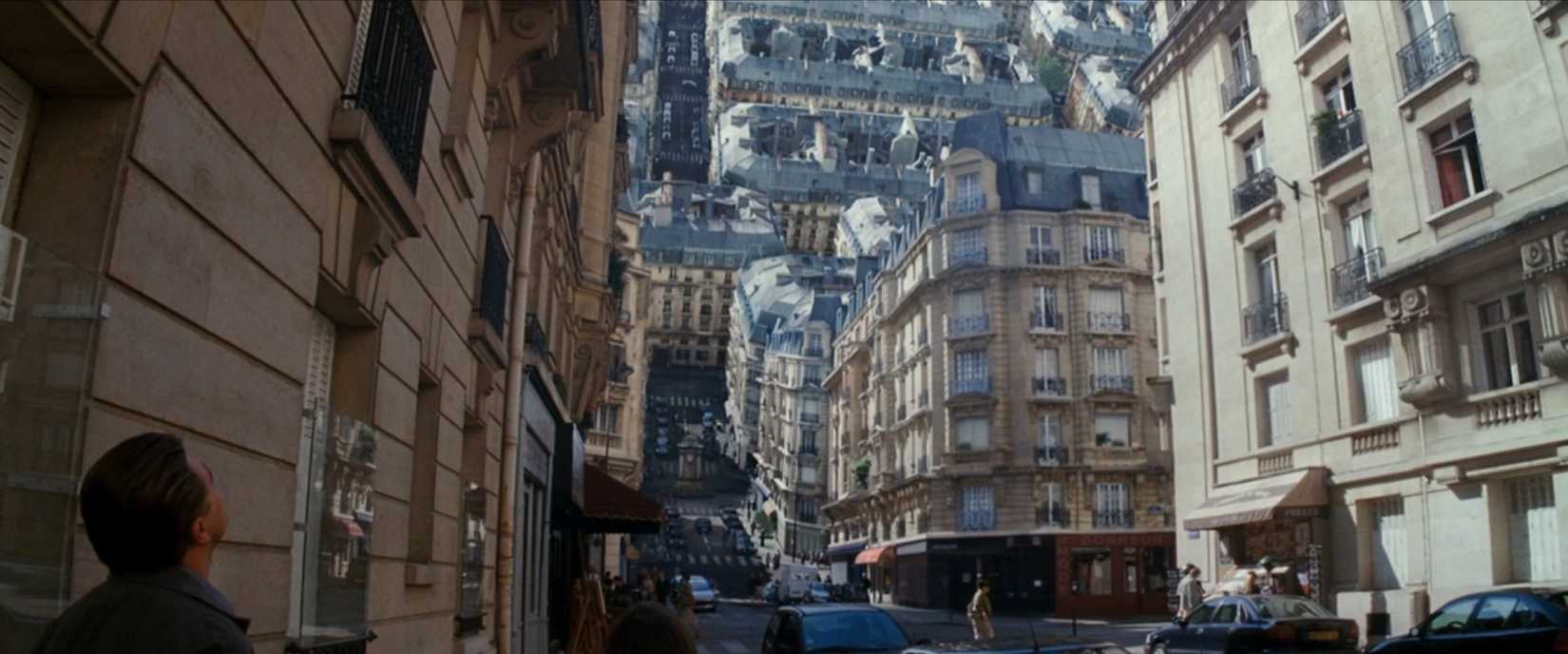 A city street folds in half, with part of it looming vertically above a horizonal stretch, as Dom (Leonardo DiCaprio) looks on in a scene from Christopher Nolan's Inception