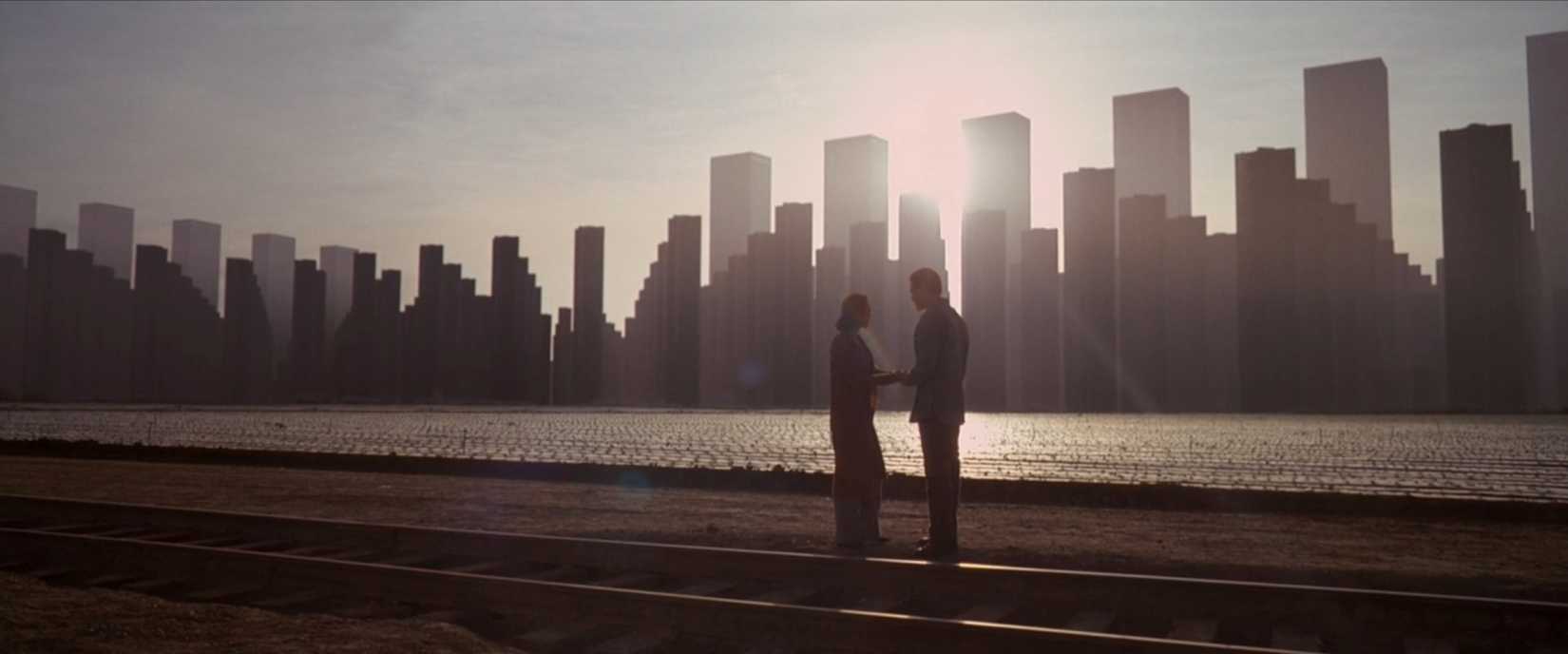 Dom (Leonardo DiCaprio) and his wife Mal (Marion Cotillard) stroll along a city skyline that's actually a dreamworld, depicted in a super-wide shot, in a scene from Inception