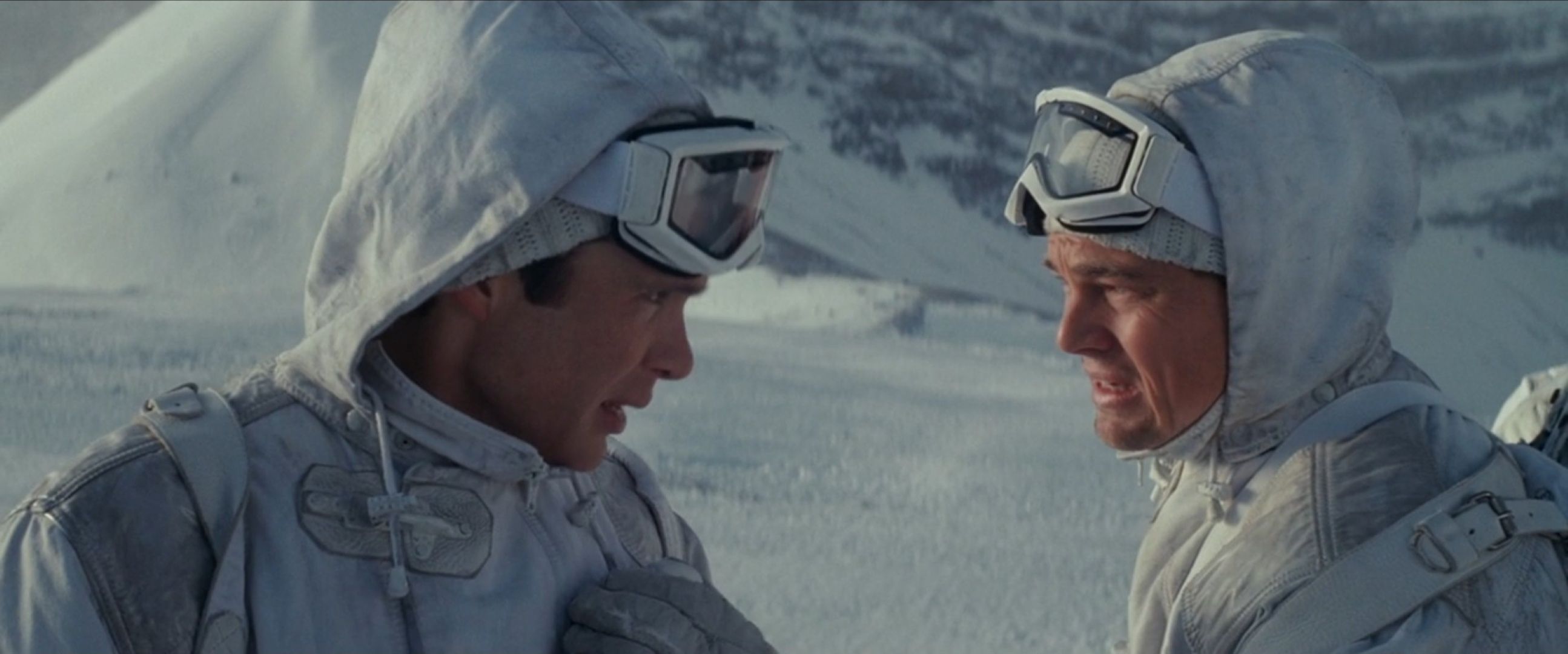 Dom (Leonardo DiCaprio) consults with Robert (Cillian Murphy) in a dream environment where they're soldiers traversing a snowy mountain in a scene from Christopher Nolan's Inception