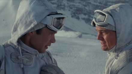 Dom (Leonardo DiCaprio) consults with Robert (Cillian Murphy) in a dream environment where they're soldiers traversing a snowy mountain in a scene from Christopher Nolan's Inception