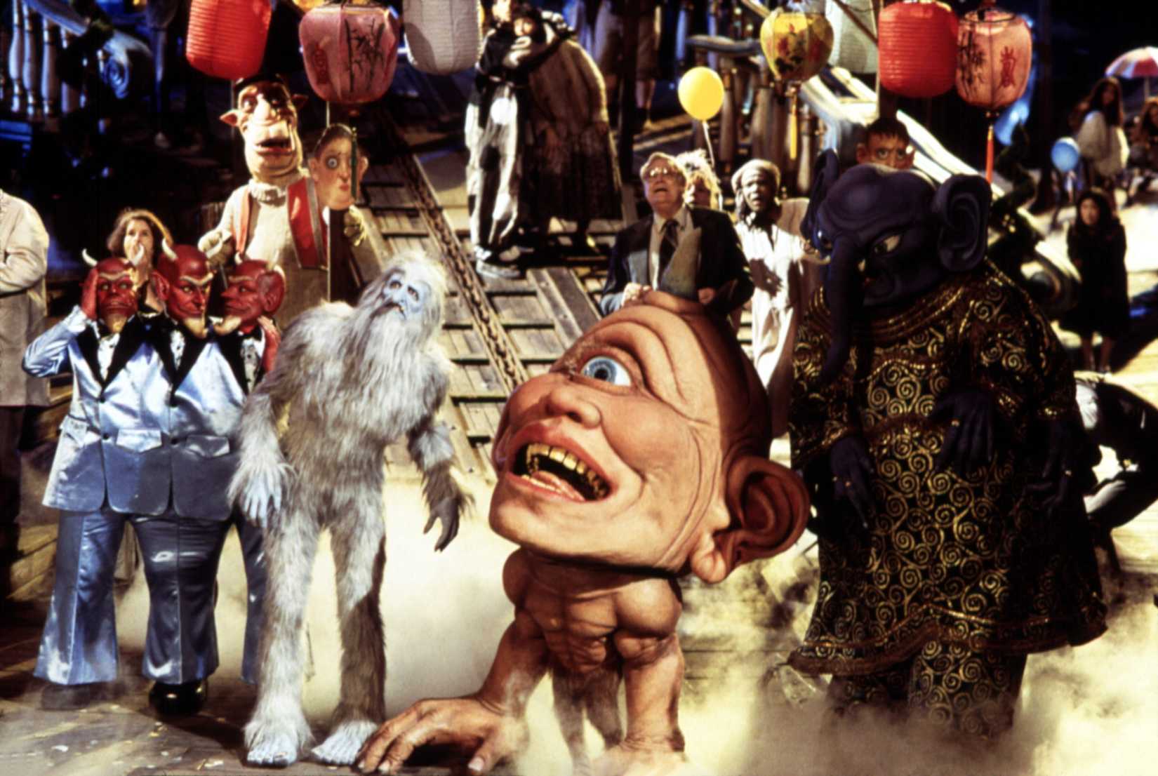 Various strange inhabitants of Down Town in Monkeybone, like a cyclops, a yeti, and a three-headed devil, all looking at something off-screen.