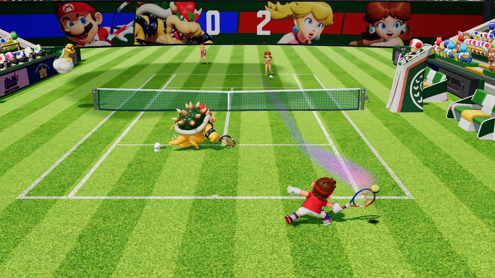 Mario dives for a return in a Mario Tennis Fever doubles match on a grass court. He's playing with Bowser; across the net are Daisy and Peach