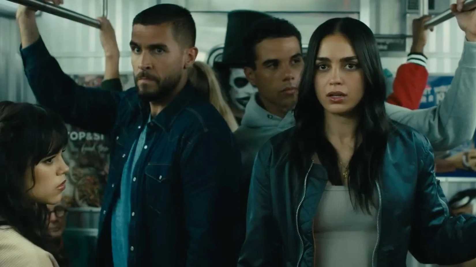 A group of young people, including Jenna Ortega as Tara Carpenter, Melissa Barrera as her older sister Sam, and Mason Gooding as Chad, stand together on a crowded New York subway in a scene from Scream 6