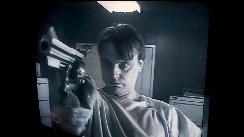 A distorted fisheye lens shot of Modell wielding a firearm