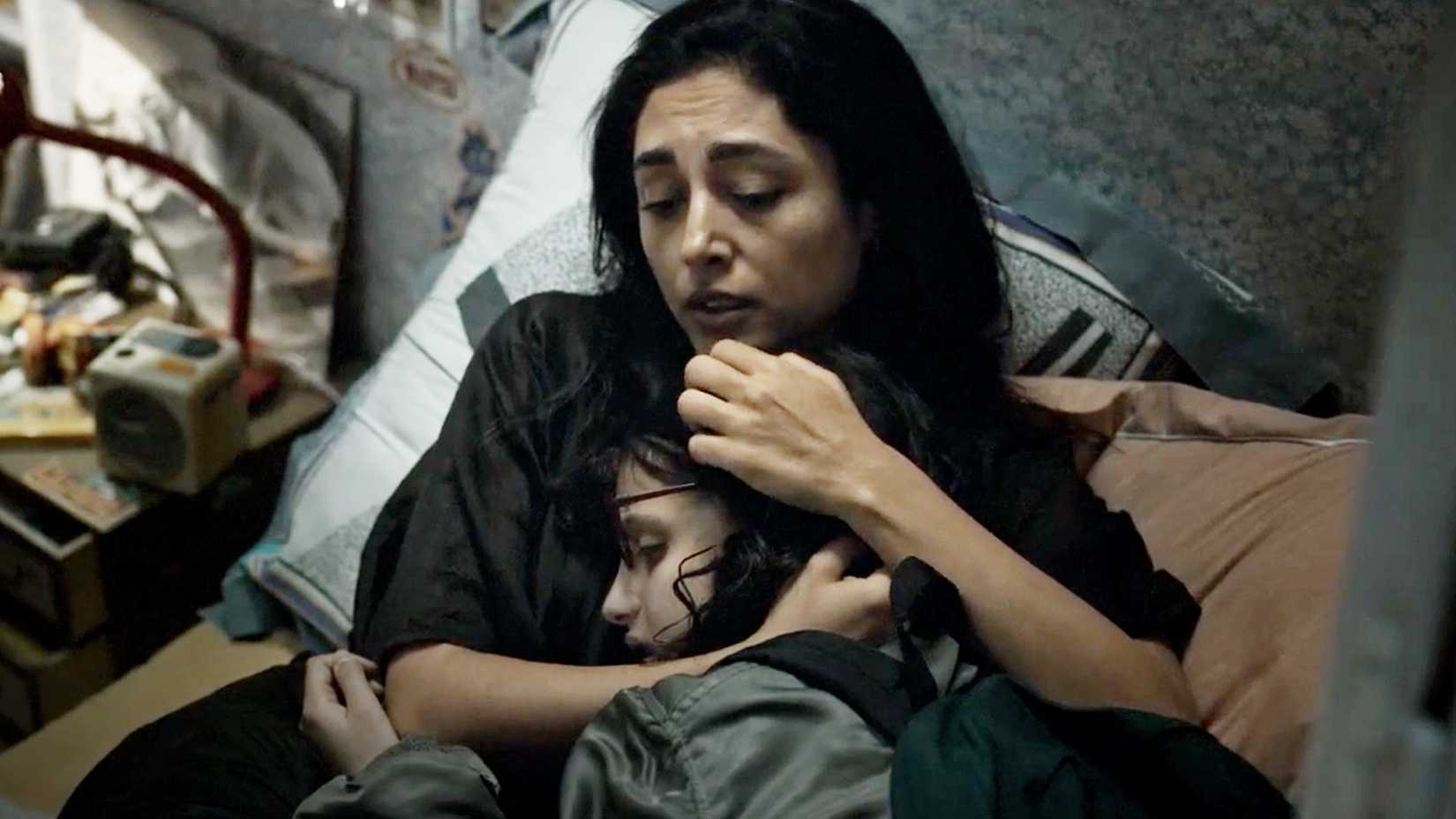 A mother (Golshifteh Farahani) holds her teenage daughter Alpha (Mélissa Boros) in her arms in a scene from the movie Alpha (2025).