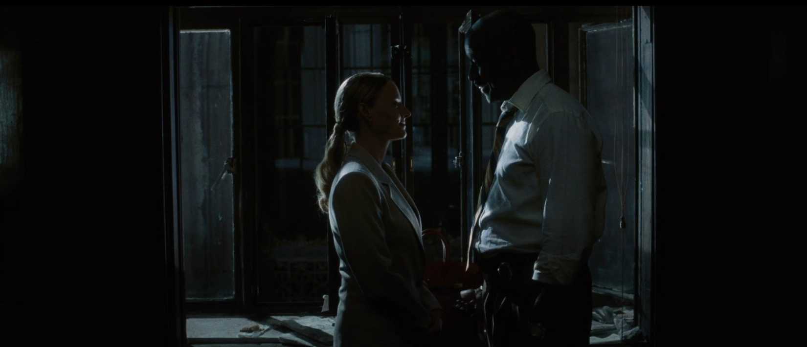 A noirish, shadowy image of Denzel Washington and Jodie Foster facing off in a tense discussion, shot from a medium distance, in a scene from Spike Lee's film Inside Man