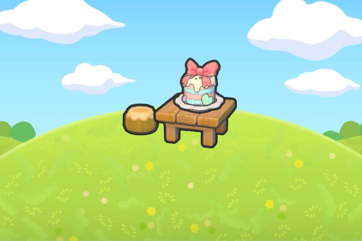 A multicolored tiererd cake on top of a wooden table alongside a stool on a grassy hill in Pokémon Pokopia.