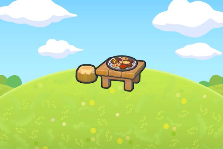 A tray of Pokémon themed cookies on top of a wooden table, next to a stool, on top of a grassy hill in Pokémon Pokopia.