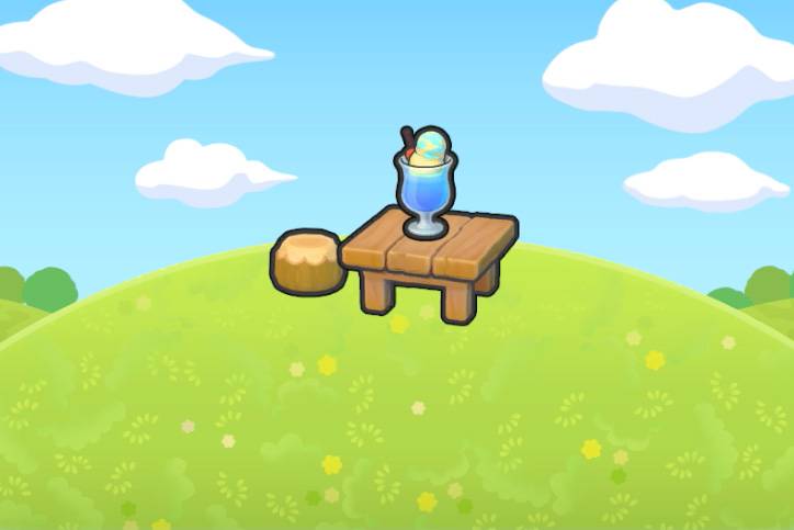 A blue drink with two scoops of ice cream on top of a wooden table on a grassy hill in Pokémon Pokopia.