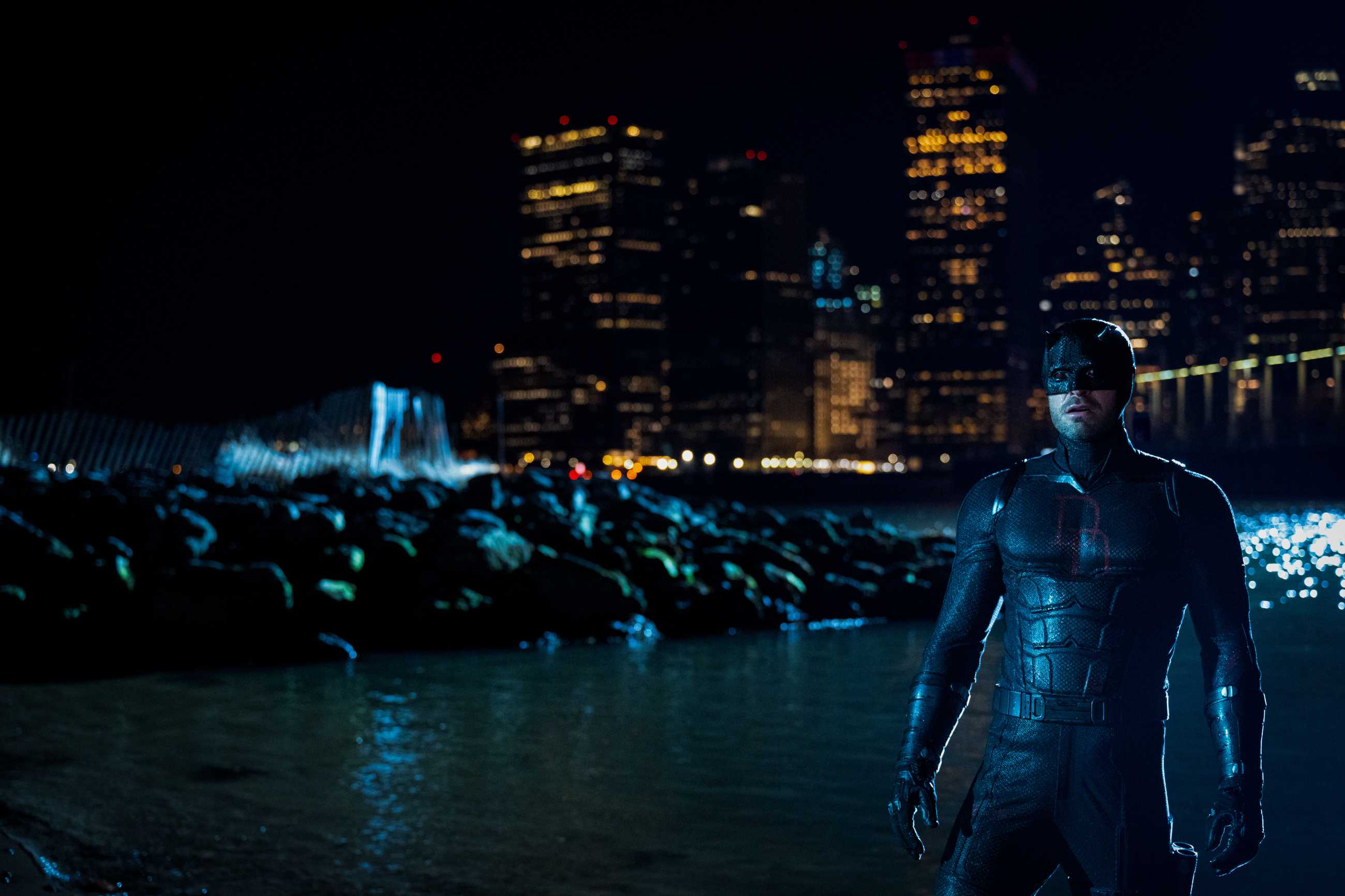 Daredevil at night with the city in the background