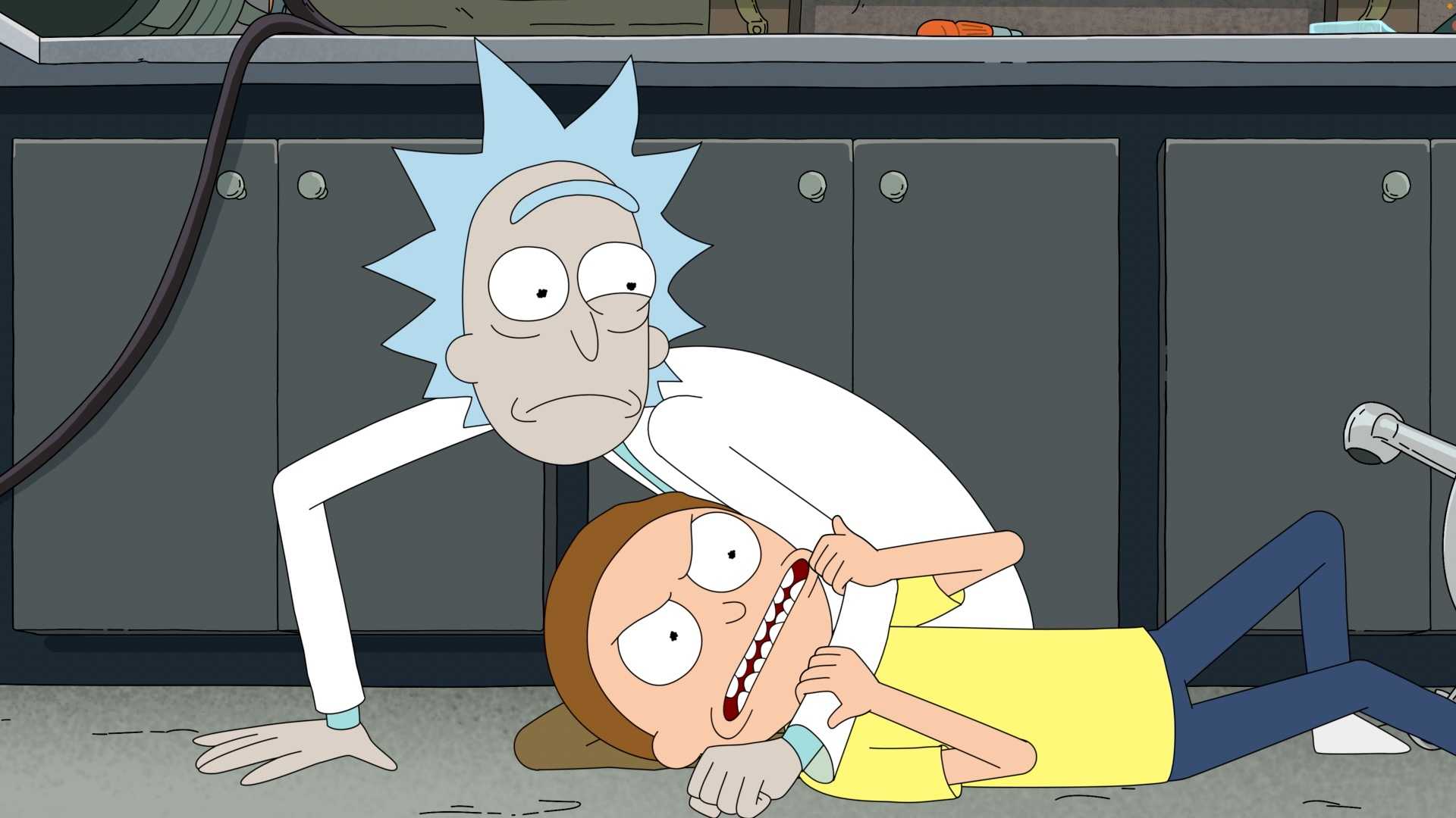 Rick looks worried as he wrestles Morty to the floor in his garage lab