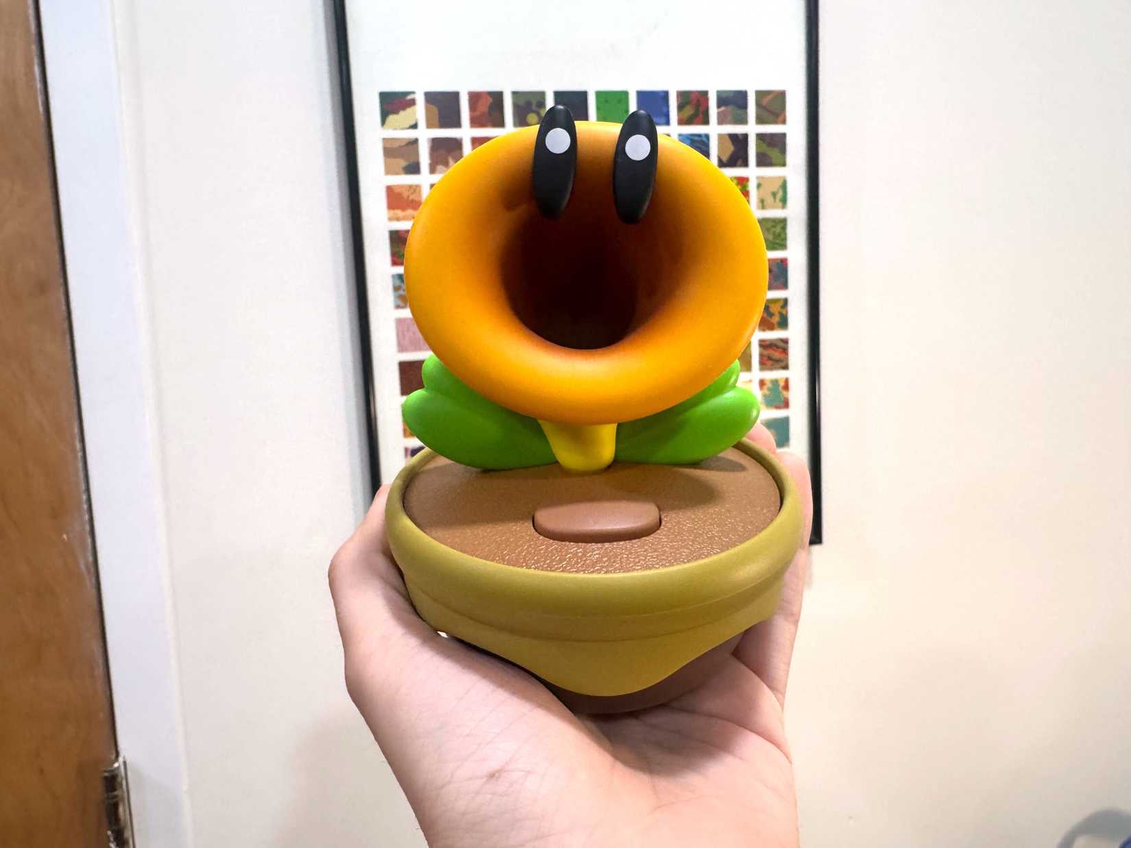 The Talking Flower toy sits in the palm of a hand.