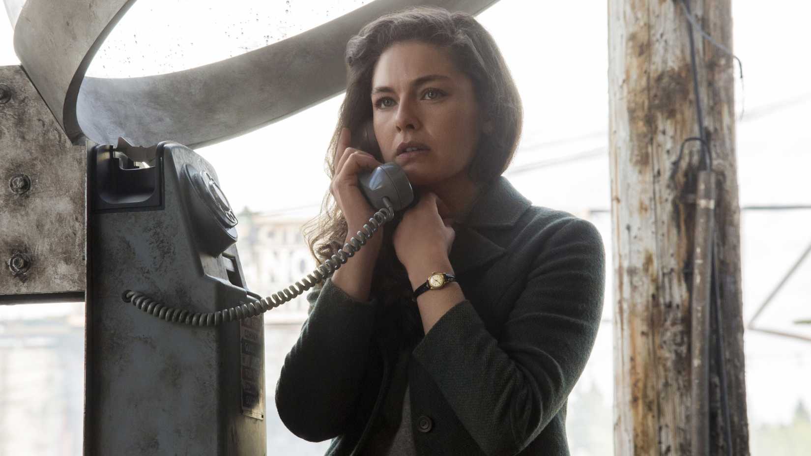 Juliana Crain (Alexa Davalos) speaks on an outdoor phone looking worried in The Man in the High Castle