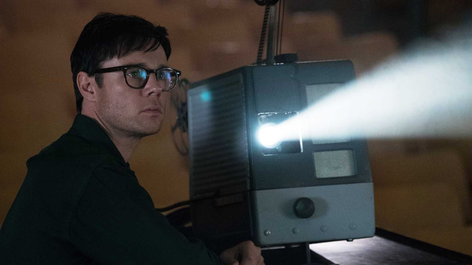 Frank Frink (Rupert Evans) watches stands by a projector watching a movie